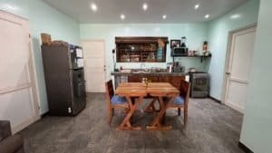Interior of a Costa Rican home with a wooden dining table and modern kitchen.