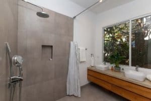 Contemporary bathroom with dual sinks, large window, and walk-in shower.