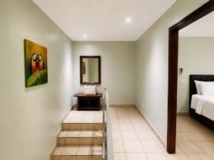 Living area with stairs and bedroom visible in Costa Rican condo.