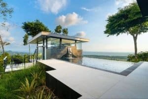 Modern house with infinity pool overlooking lush landscape and ocean in Dominical.
