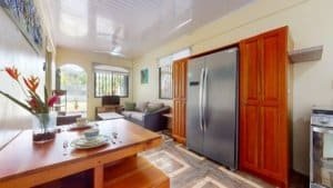 Interior view of a cozy Costa Rican kitchen with wooden cabinets and stainless steel appliances.