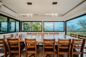 Spacious dining room with large windows overlooking the ocean and jungle.