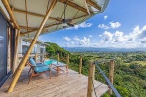 Balcony with seating overlooking lush mountain landscape in Costa Rica.
