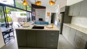 Contemporary kitchen in Costa Rica with large glass doors opening to outdoor patio.
