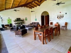 Open-concept living and dining area with high wooden ceiling and ceiling fans.