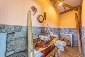 Bathroom featuring natural wood accents, stone wall, and eco-friendly design elements.