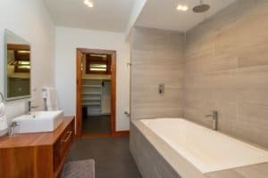 Modern bathroom with bathtub, sink, and walk-in shower in mountain retreat.