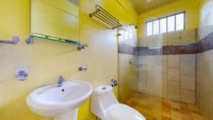 Bright yellow bathroom with walk-in shower and modern fixtures.