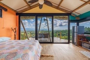 Interior view of a bedroom with mountain views and balcony in Dominical, Costa Rica.