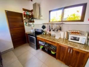 Kitchen with wooden cabinets, granite countertop, and ocean view window.