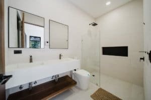 Contemporary bathroom with dual sinks, walk-in shower, and minimalist design.