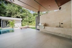 Contemporary outdoor kitchen with pool and lush greenery in Dominical.