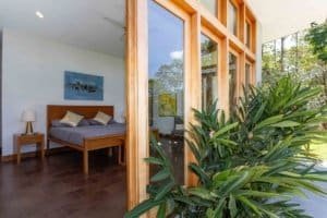 Interior view of a bedroom with wooden furniture and large windows in a mountain home.