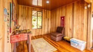Interior of a mountain home with wooden walls, a window, and seating area.
