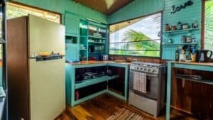 Interior of a colorful Costa Rican kitchen with tropical scenery outside.