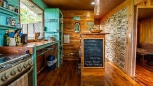 Interior view of a rustic mountain home in Costa Rica with wooden accents and kitchen area.