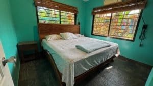 Comfortable bedroom with wooden furniture and tropical views in Dominical.