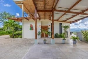 Contemporary Costa Rican home entrance with potted plants and mountain view.