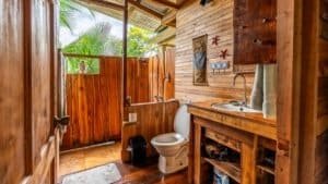Cozy rustic bathroom with wooden accents and tropical view in Costa Rica.