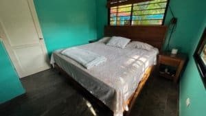 Comfortable bedroom with large window and tropical decor in Dominical.