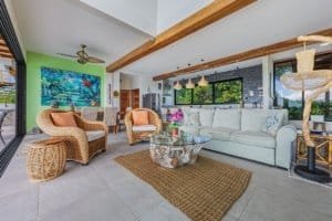 Modern living room with mountain views, colorful art, and stylish furniture in Dominical.