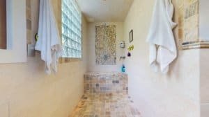 Modern bathroom with walk-in shower and natural stone tiles in Costa Rica.