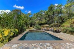 Pool with mountain view, lush greenery, and outdoor seating in Dominical.