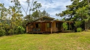 Rustic wooden mountain home with guest cabin in lush Costa Rican landscape.