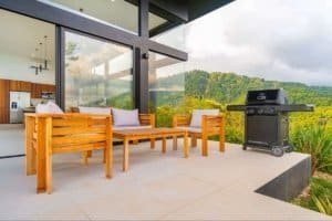 Outdoor patio with wooden furniture and ocean view in Dominical, Costa Rica.