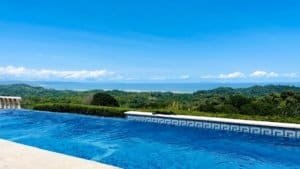 Infinity pool overlooking lush green landscape and ocean in Dominical.