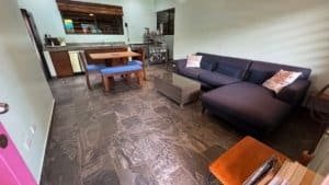Spacious living room with black sofa, dining area, and kitchen in Dominical.