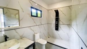 Contemporary bathroom with marble walls, walk-in shower, and toilet in Costa Rica.