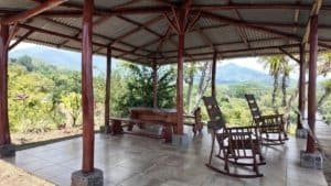 Covered outdoor patio with rocking chairs and mountain view in Dominical.