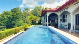 Elegant villa with pool, lush greenery, and mountain views in Costa Rica.