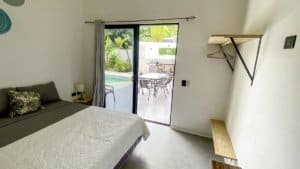 Bedroom with sliding glass door leading to outdoor patio and pool area.
