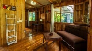 Interior of a wooden mountain home with large windows and cozy furnishings.