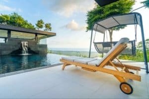 Panoramic ocean view from luxury Costa Rican home with pool and lounge chairs.