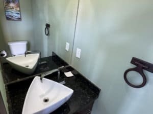 Contemporary bathroom with dual vessel sinks and black granite countertop.