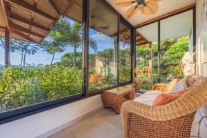 Cozy sunroom with wicker furniture and mountain views in Dominical.