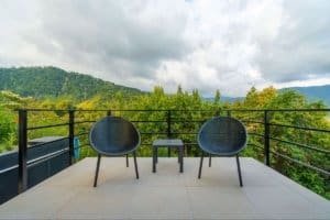 Balcony with two chairs overlooking lush green mountains in Dominical, Costa Rica.