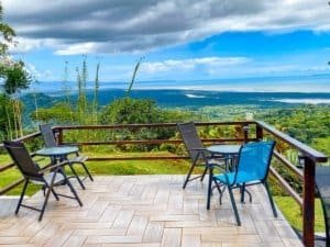 Balcony with chairs overlooking lush landscape and ocean in Dominical.