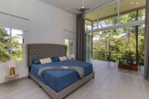 Modern bedroom with mountain view and balcony in Costa Rica.