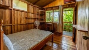 Interior view of a rustic mountain cabin bedroom with wooden walls and a balcony.