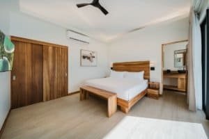 Bright bedroom with wooden furniture and large window with curtains.