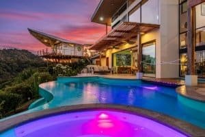 Modern Costa Rica estate with infinity pool and mountain backdrop at sunset.