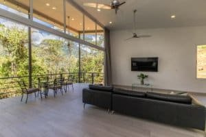 Modern living room with panoramic mountain views and glass walls.