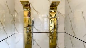 Modern gold shower fixtures in a luxurious bathroom setting.