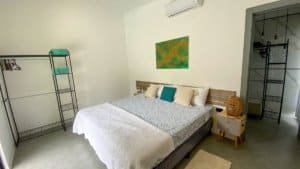 Comfortable bedroom with king bed, colorful pillows, and minimalist decor in Dominical.