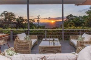 Balcony with seating overlooking mountains at sunset in Dominical, Costa Rica.
