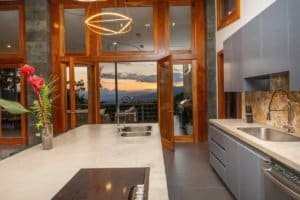 Modern kitchen with mountain view, open doors, and stylish decor in Dominical.